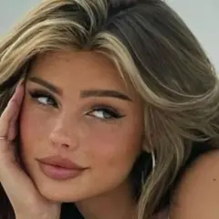 Primer plano de una joven con cabello castaño y rubio, con baby hairs peinados hacia atrás y un delineado de ojos dramático.