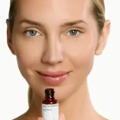 Mujer sonríe sosteniendo un frasco de sérum de retinol. Descubre para qué sirve el retinol y cómo puede mejorar tu piel.
