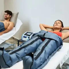 Dos personas disfrutan de la presoterapia, un tratamiento para mejorar la circulación y reducir la hinchazón.