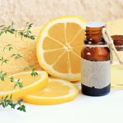 Aceite esencial de limón, con rodajas de limón y ramitas de tomillo. El limoneno es un componente clave.