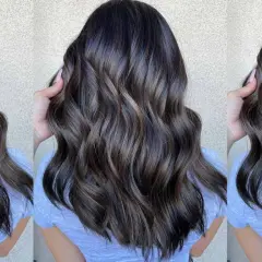 Cabello castaño oscuro con reflejos cenizos y ondas suaves.