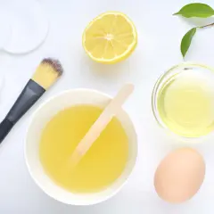 Ingredientes para una mascarilla casera para el pelo: huevo, limón, aceite y aplicador.