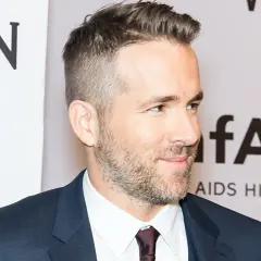Ryan Reynolds luce un corte de pelo moderno con degradado hombre, barba cuidada y traje oscuro.