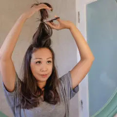Mujer se corta el pelo en casa, creando un corte de pelo a capas.