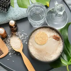 Ingredientes para un tratamiento capilar: arroz, agua de arroz, aceites y peine.