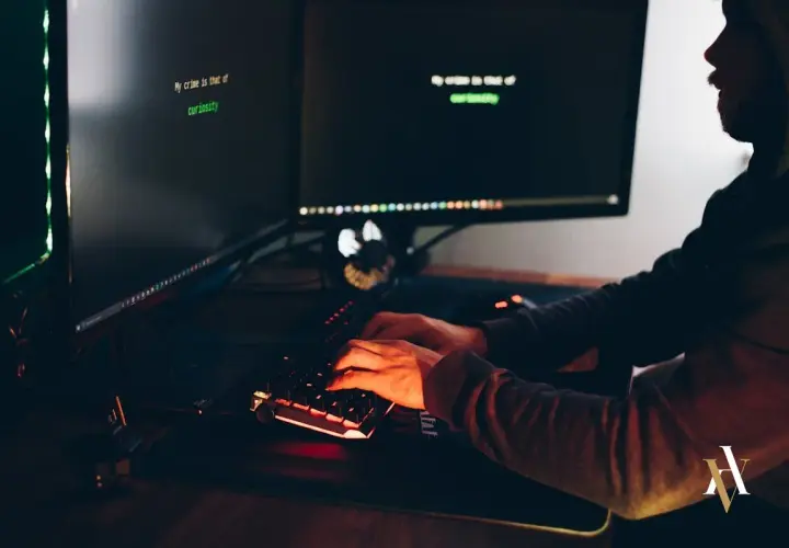 Persona teclea en un ordenador, con texto en pantalla: "My crime is that of curiosity". Podría ser un hacker resolviendo preguntas frecuentes sobre los penaltis digitales.