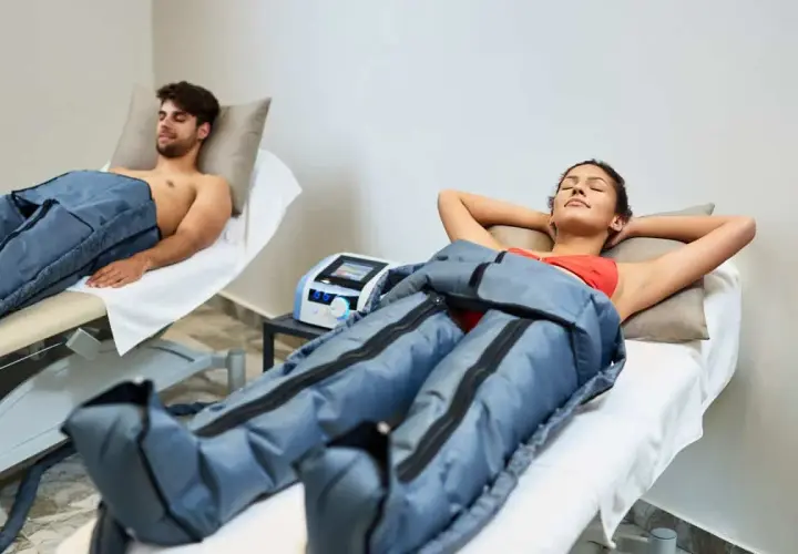 Dos personas disfrutan de la presoterapia, un tratamiento para mejorar la circulación y reducir la hinchazón.