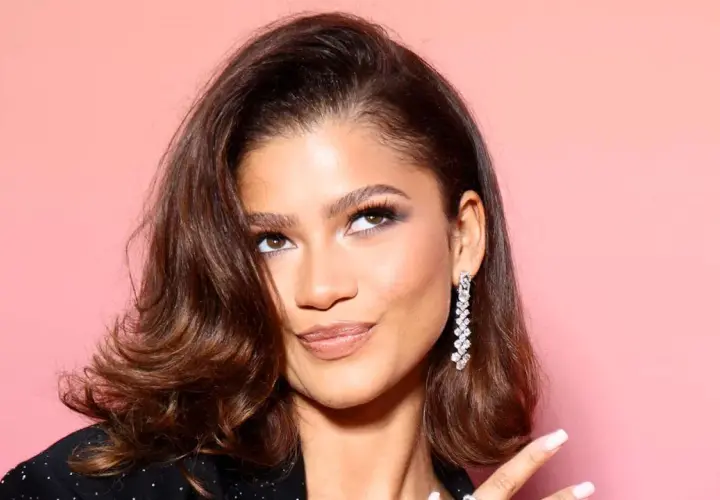 Zendaya luce un elegante corte midi con ondas suaves y un pendiente de diamantes deslumbrante.