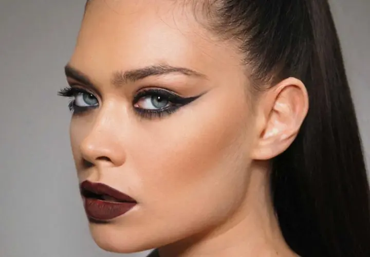 Ojos dramáticos con delineado cat eye y labios oscuros, resaltando el uso de kohl para una mirada intensa.