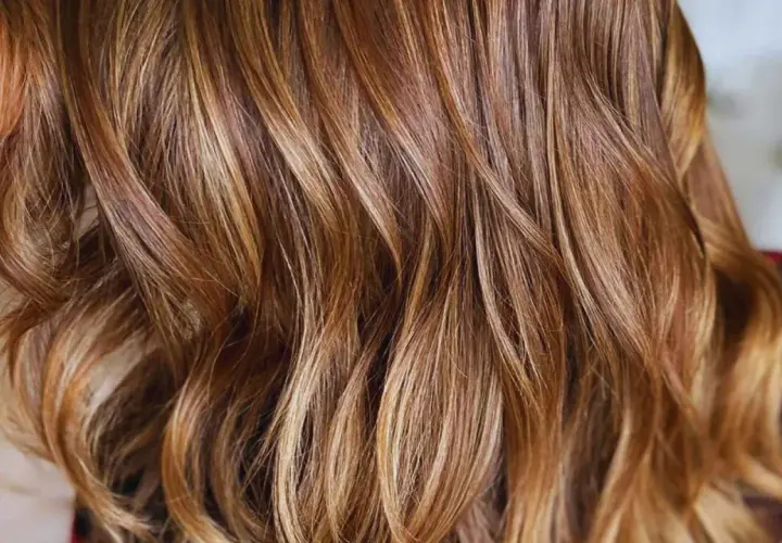 Cabello castaño con mechas rubias que le dan un brillo natural y moderno.