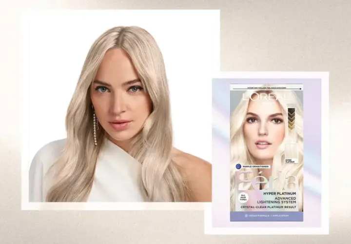 Mujer con pelo rubio platino, resultado de decoloración pelo. Caja de tinte L'Oréal Féria Hyper Platinum.