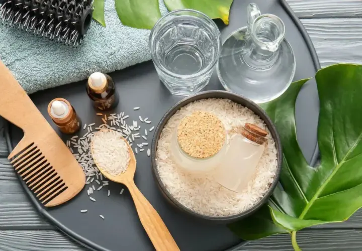 Ingredientes para un tratamiento capilar: arroz, agua de arroz, aceites y peine.