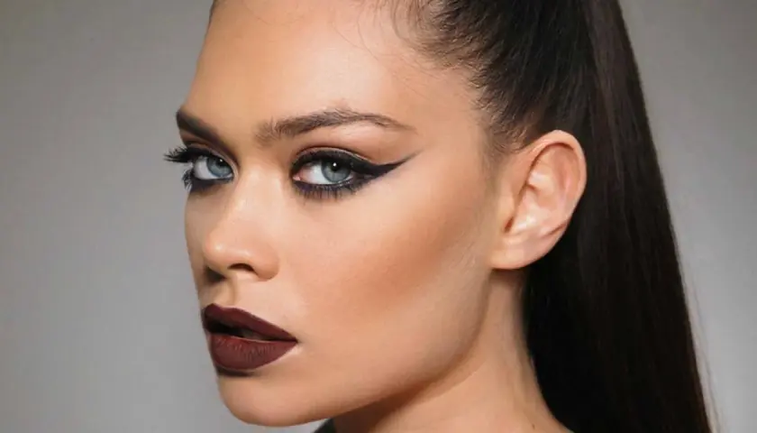 Ojos dramáticos con delineado cat eye y labios oscuros, resaltando el uso de kohl para una mirada intensa.