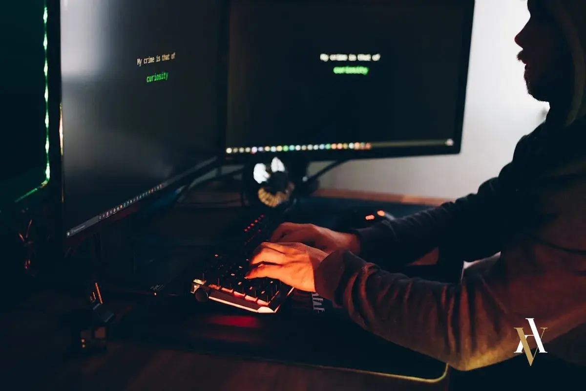 Persona teclea en un ordenador, con texto en pantalla: "My crime is that of curiosity". Podría ser un hacker resolviendo preguntas frecuentes sobre los penaltis digitales.