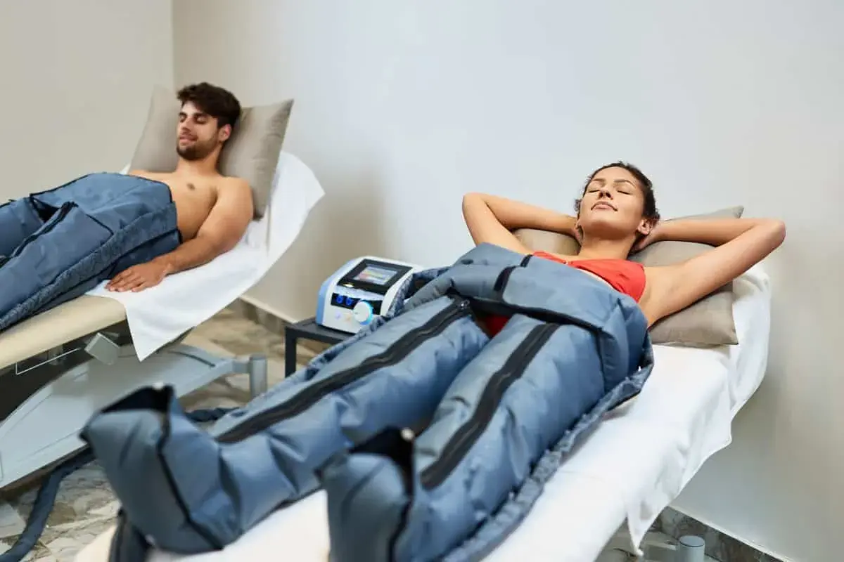Dos personas disfrutan de la presoterapia, un tratamiento para mejorar la circulación y reducir la hinchazón.