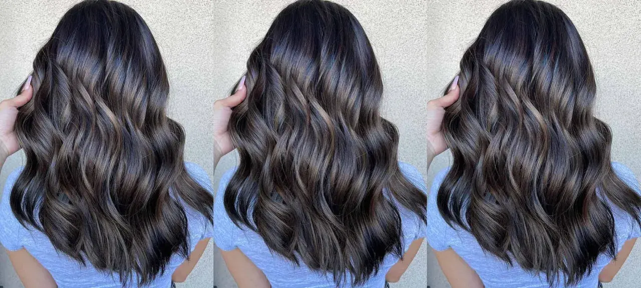 Cabello castaño oscuro con reflejos cenizos y ondas suaves.